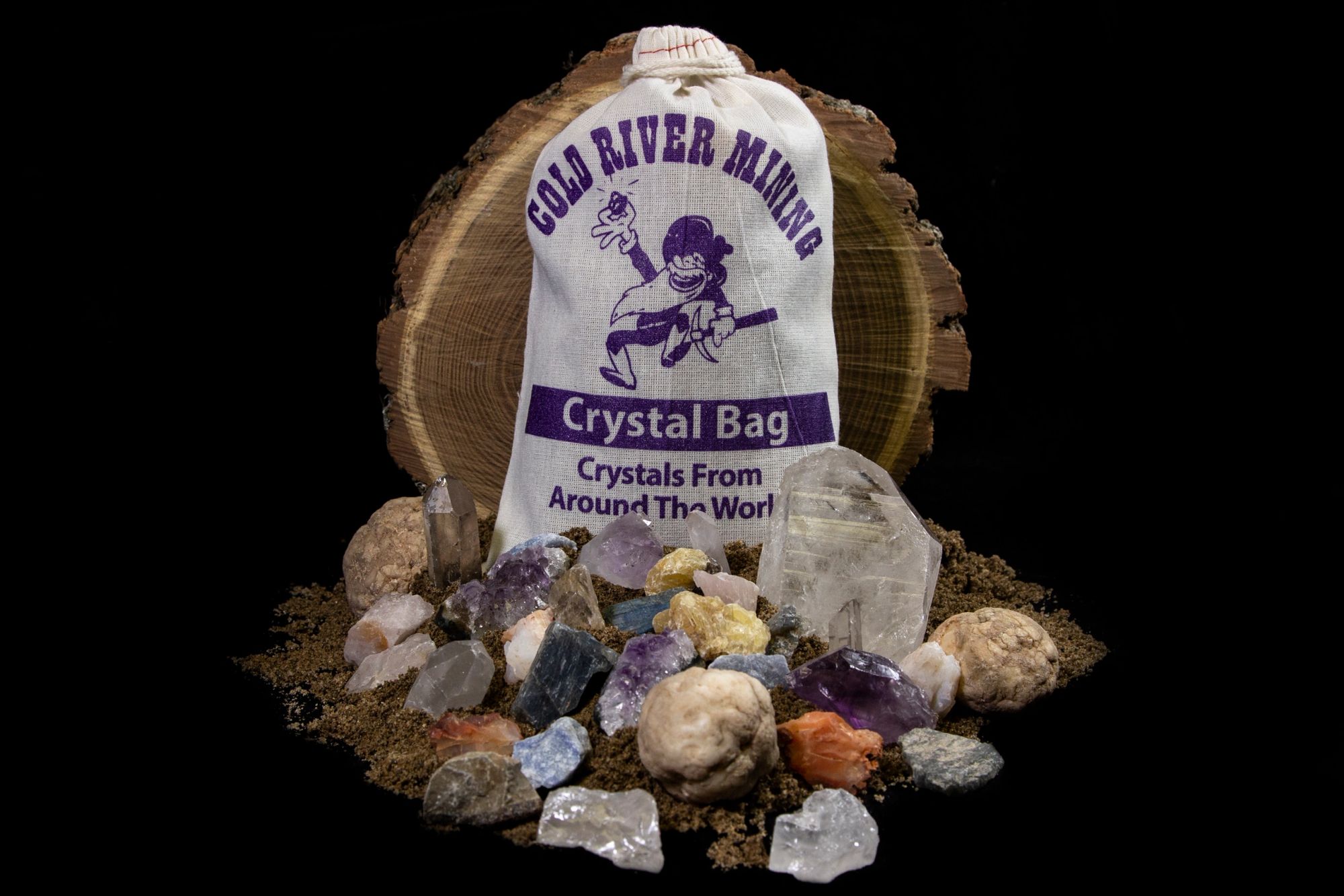 A cloth crystal bag beside a spill of crystals from around the world