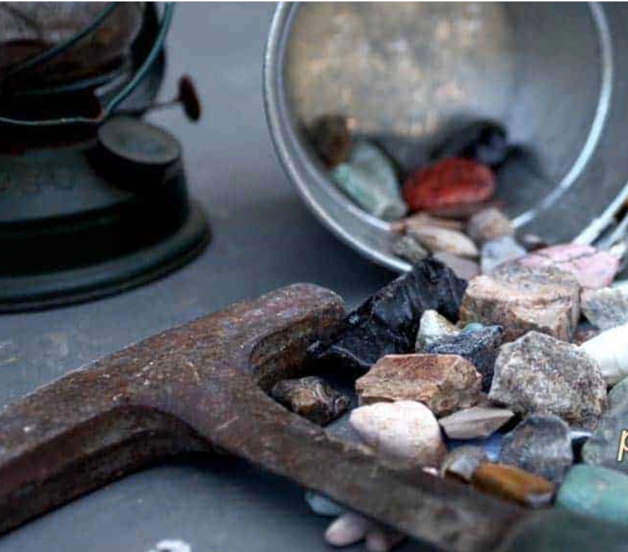 Colorful stones and minerals caught in a metal screening sieve